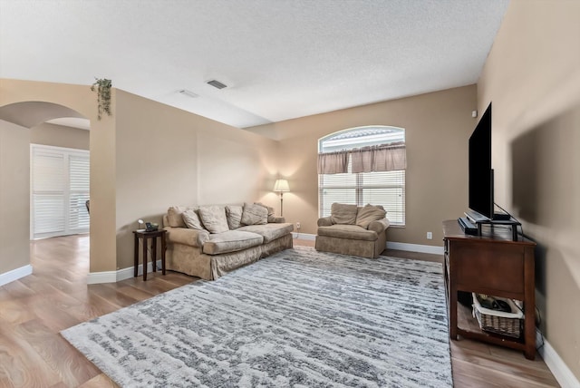 living room with a textured ceiling and light hardwood / wood-style floors