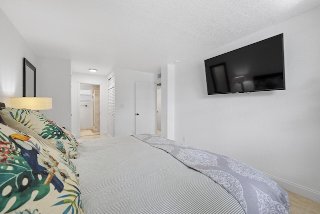 bedroom featuring connected bathroom and a textured ceiling