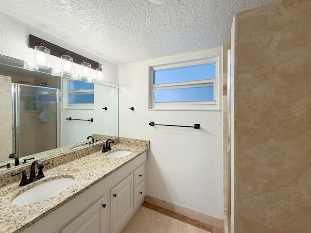 bathroom featuring a textured ceiling, a shower with door, vanity, and tile patterned flooring