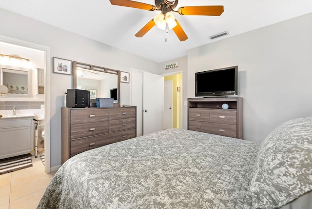 bedroom featuring ceiling fan, ensuite bath, and light tile patterned floors