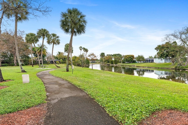 view of home's community featuring a lawn and a water view