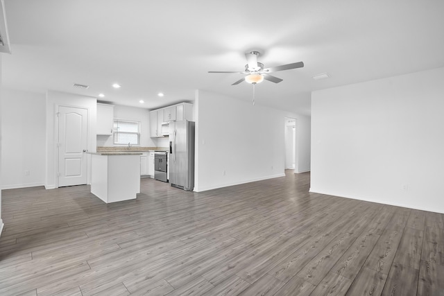 unfurnished living room with ceiling fan and light hardwood / wood-style floors