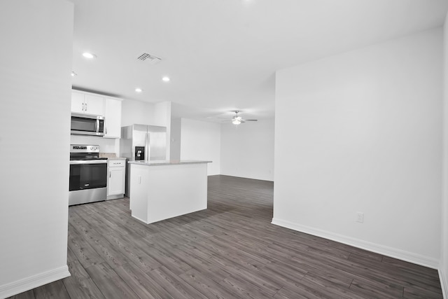 kitchen with ceiling fan, appliances with stainless steel finishes, white cabinets, a kitchen island, and dark hardwood / wood-style flooring