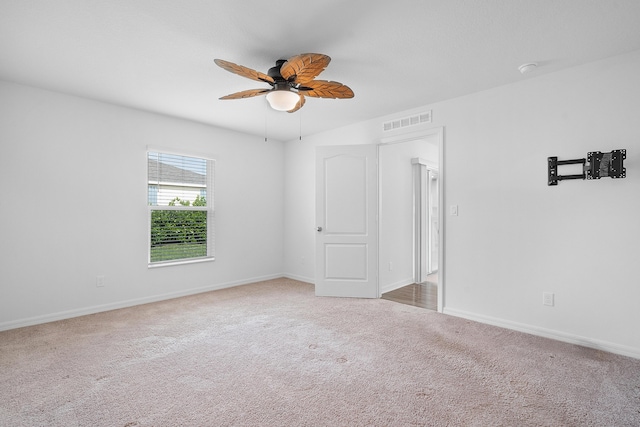 carpeted spare room featuring ceiling fan