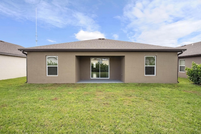 rear view of property featuring a yard