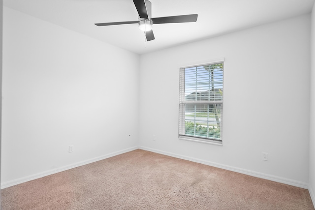 carpeted spare room featuring a wealth of natural light and ceiling fan