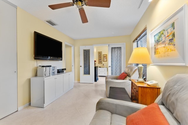 tiled living room featuring a textured ceiling and ceiling fan