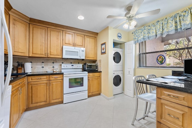 kitchen with white appliances, stacked washing maching and dryer, dark stone countertops, decorative backsplash, and ceiling fan