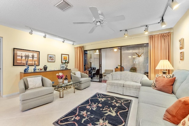 tiled living room with a textured ceiling, ceiling fan, and track lighting