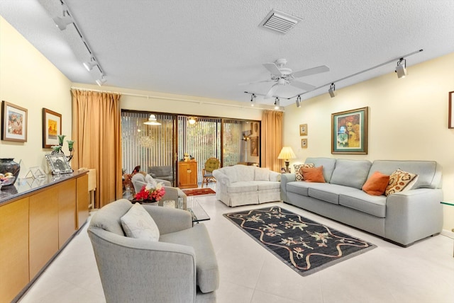 tiled living room with rail lighting, a textured ceiling, and ceiling fan