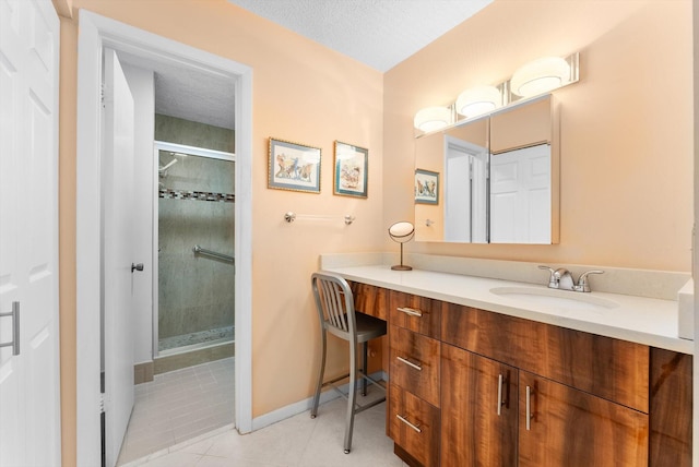 bathroom with a textured ceiling, a shower with door, tile patterned flooring, and vanity