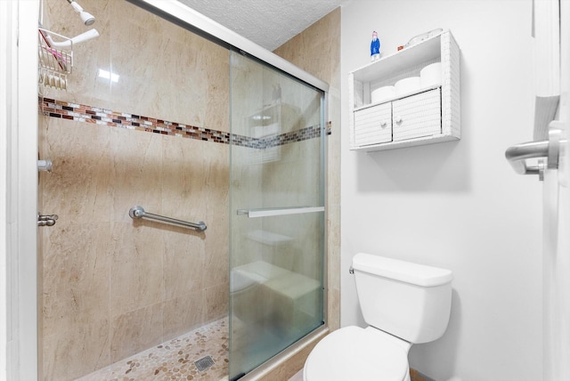 bathroom with toilet, an enclosed shower, and a textured ceiling