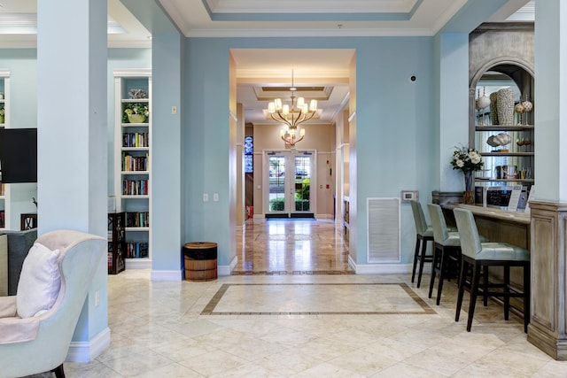 entryway featuring french doors, crown molding, a chandelier, a raised ceiling, and a high ceiling