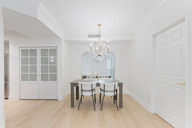 dining room with ornamental molding, a chandelier, and light hardwood / wood-style flooring