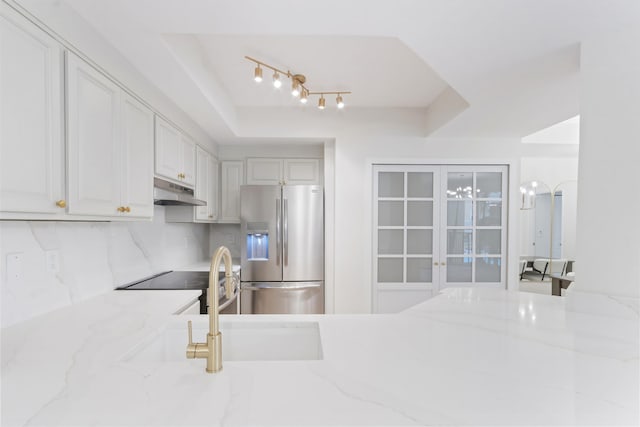 kitchen with light stone countertops, sink, stove, and stainless steel fridge with ice dispenser