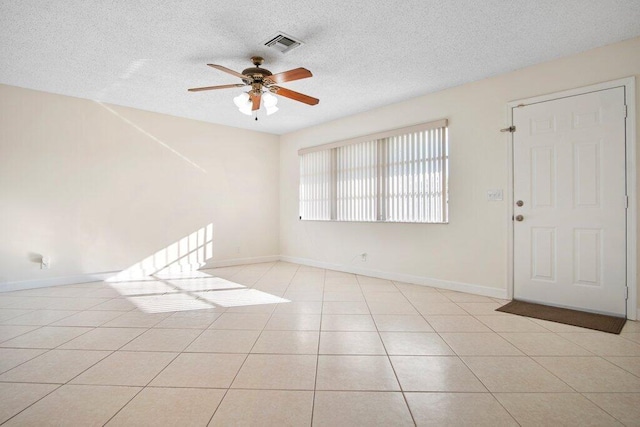 tiled spare room featuring ceiling fan and a textured ceiling