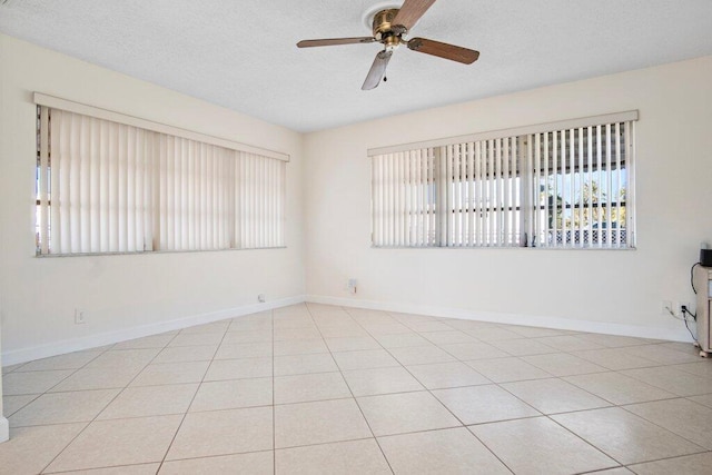 tiled spare room with ceiling fan