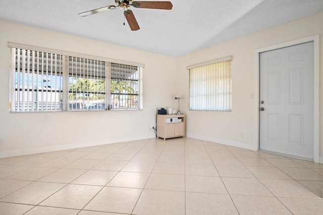 tiled empty room featuring a wealth of natural light and ceiling fan