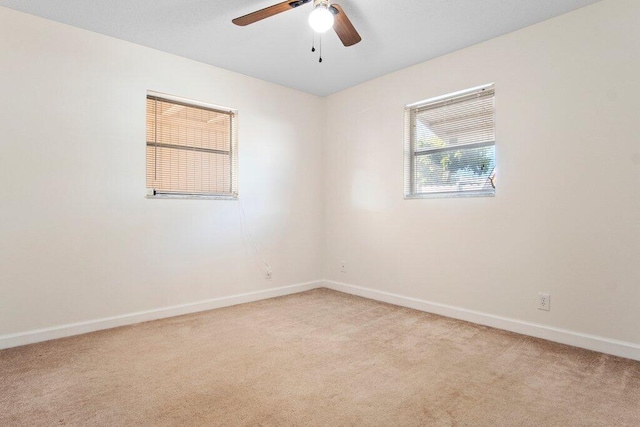 empty room with ceiling fan and light carpet