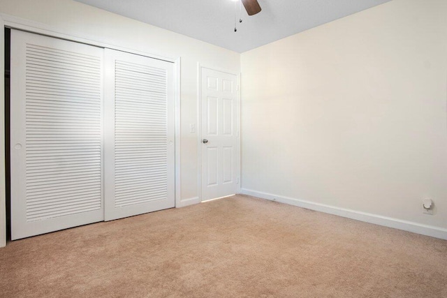 unfurnished bedroom featuring light carpet, a closet, and ceiling fan