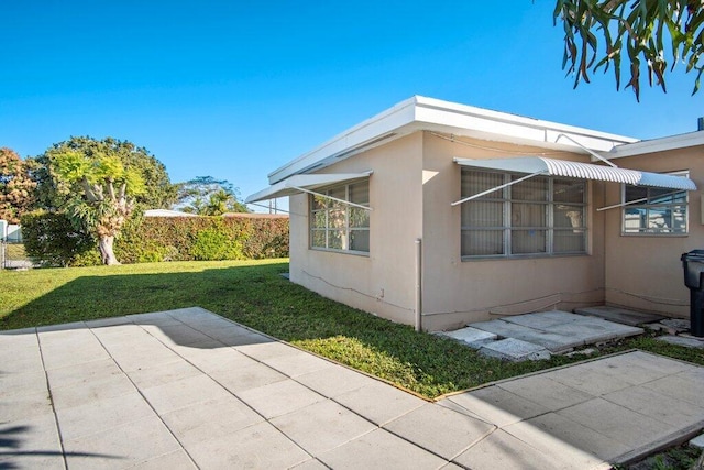 view of side of property featuring a patio area and a yard