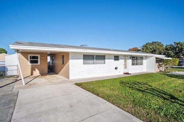 ranch-style house featuring a front lawn and a carport