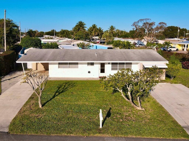 ranch-style house with a carport, concrete driveway, and a front lawn