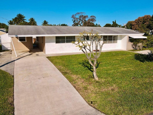 single story home featuring a front yard, driveway, a carport, and fence