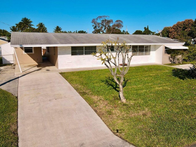 ranch-style home with a carport and a front lawn