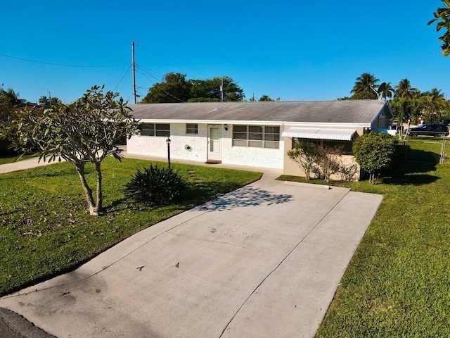 single story home featuring a front lawn and concrete driveway