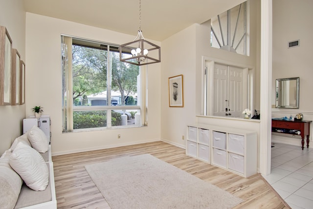 interior space with light hardwood / wood-style flooring and an inviting chandelier