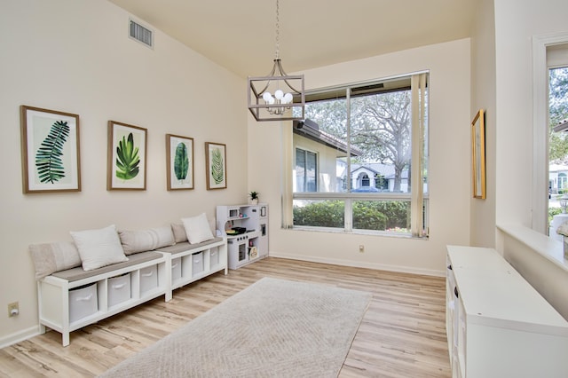 living area featuring light wood-type flooring and an inviting chandelier