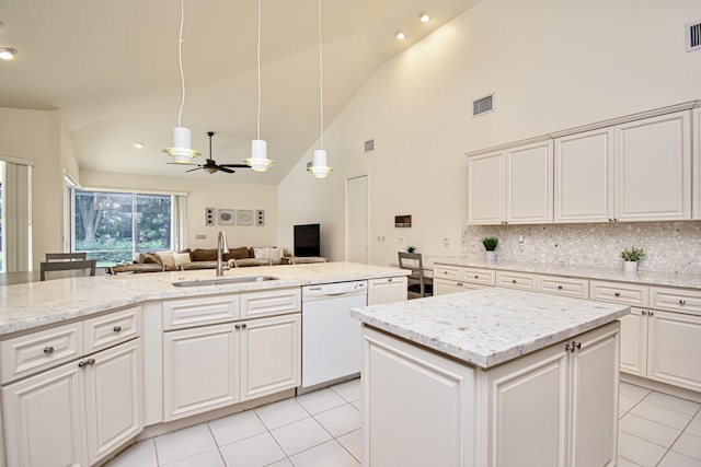 kitchen with tasteful backsplash, dishwasher, hanging light fixtures, sink, and an island with sink