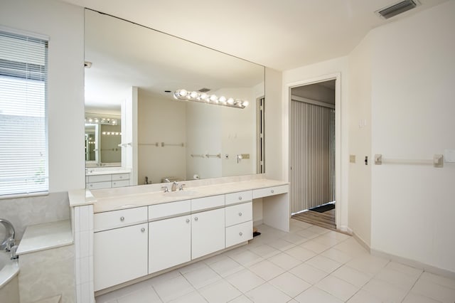 bathroom featuring plenty of natural light, a bathing tub, tile patterned floors, and vanity