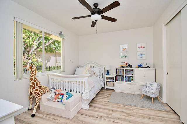 bedroom with ceiling fan, light hardwood / wood-style flooring, and a closet