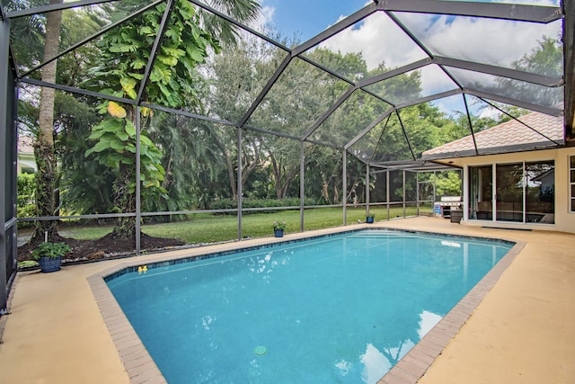 view of pool with a patio area, a lanai, and grilling area