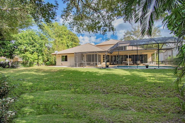 rear view of property with a lanai and a lawn