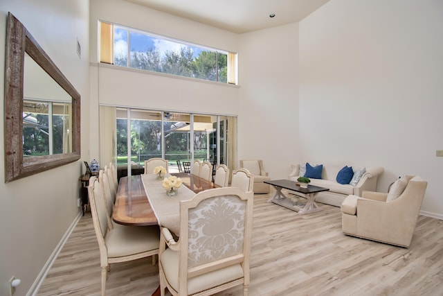 dining area featuring a high ceiling and light hardwood / wood-style floors