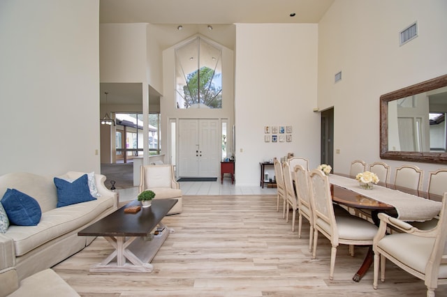 living room with a high ceiling and light hardwood / wood-style floors