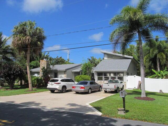 view of front of property with concrete driveway, a front lawn, and fence