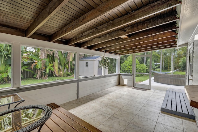 unfurnished sunroom featuring wood ceiling and beamed ceiling