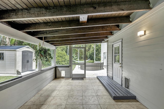 unfurnished sunroom with vaulted ceiling with beams and wood ceiling