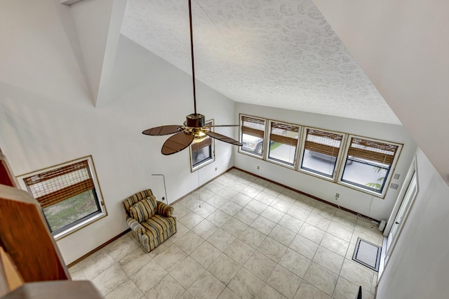 interior space with ceiling fan, plenty of natural light, a textured ceiling, and vaulted ceiling