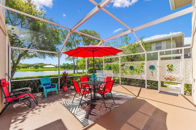 view of patio / terrace featuring a water view and glass enclosure