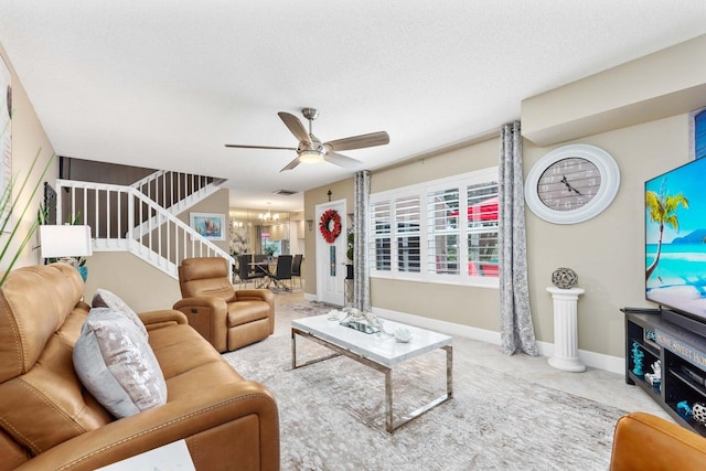 living room with a textured ceiling and ceiling fan with notable chandelier