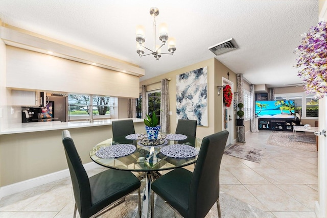 dining space with light tile patterned floors, a chandelier, and a textured ceiling