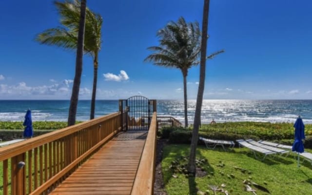 surrounding community with a water view and a view of the beach