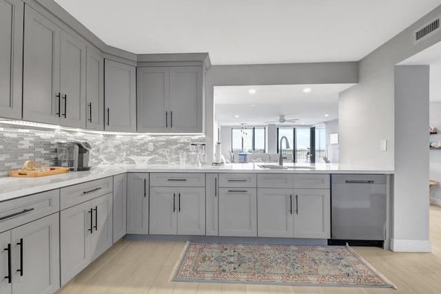 kitchen featuring dishwasher, decorative backsplash, sink, gray cabinets, and ceiling fan