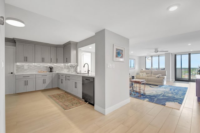 kitchen featuring gray cabinets, ceiling fan, tasteful backsplash, dishwasher, and sink