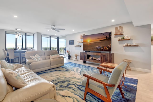 living room with ceiling fan and a wall of windows